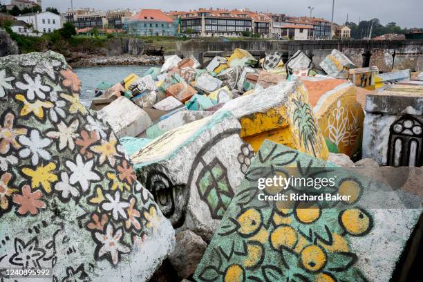 Carefully painted concrete breakwater blocks help with coastal erosion in a Spanish harbour, on 13th May 2022, in Llanes, Cantabria, Spain.