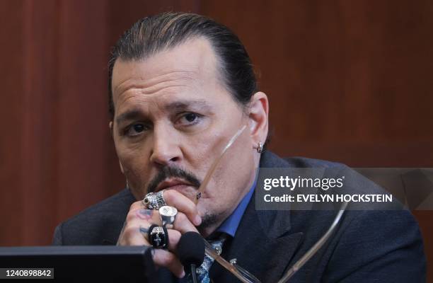 Actor Johnny Depp listens to a question as he testifies in the courtroom during his defamation trial against his ex-wife Amber Heard, at the Fairfax...