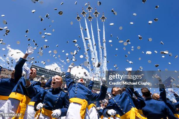 Air Force Academy cadets toss their hats in the air as the Air Force Thunderbirds fly over at the conclusion of the graduation ceremony for the Class...