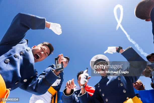 Air Force Academy cadets celebrate after their graduation ceremony as the Air Force Thunderbirds fly overhead at Falcon Stadium on May 25, 2022 in...