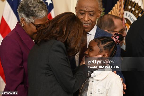 Vice President Kamala Harris speaks to Gianna Floyd, daughter of George Floyd, following a signing ceremony in the East Room of the White House in...
