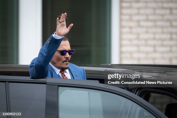Johnny Depp waves to his fans as he departs at the close of the days testimony outside court during the Johnny Depp and Amber Heard civil trial at...
