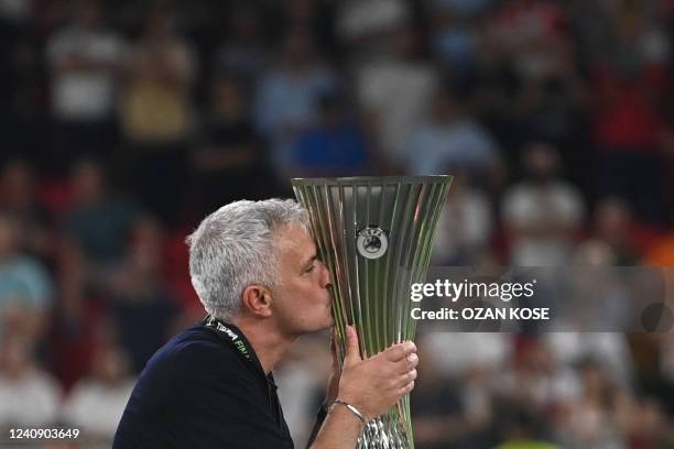 Roma's Portuguese head coach Jose Mourinho kisses the trophy as his team celebrates winning the UEFA Europa Conference League final football match...