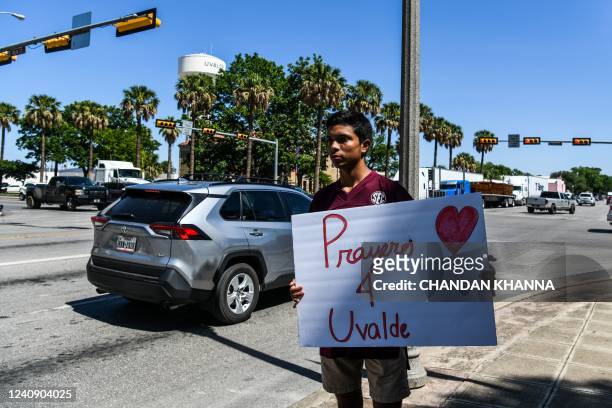 Local resident holds a placard that reads Prayers 4 Uvalde as they grieve for the victims of the mass shooting at Robb Elementary School in Uvalde,...