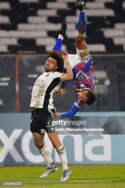 Robson of Fortaleza falls down as he collides against Maximiliano Falcon of Colo Colo at Estadio Monumental David Arellano on May 25, 2022 in...