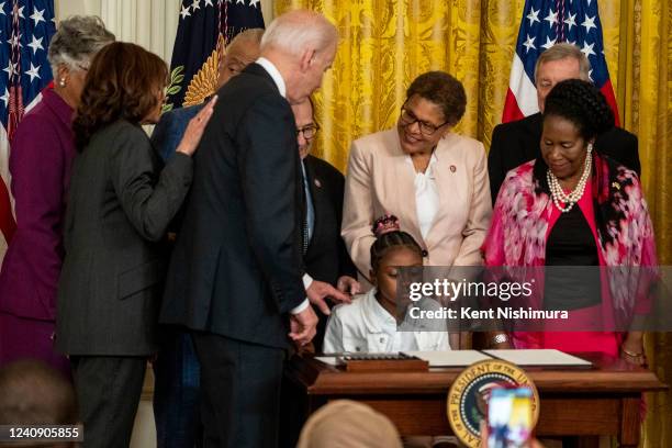 Gianna Floyd looks at the signed executive order to advance policing and strengthen public safety as President Joe Biden looks at her in the East...