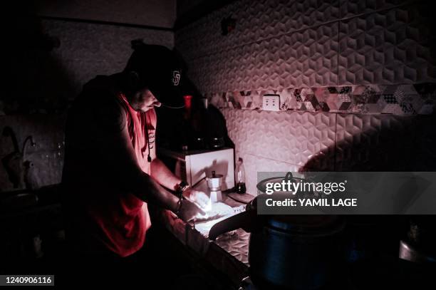 Man lights a candle during a blackout in Havana, on May 25, 2022. - The main thermoelectric central of Cuba was reached Tuesday by a lightning that...