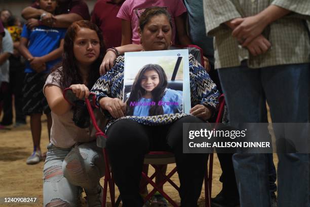 Woman holds a photo of Nevaeh Bravo, who was killed in the mass shooting, during a vigil for the victims of the mass shooting at Robb Elementary...