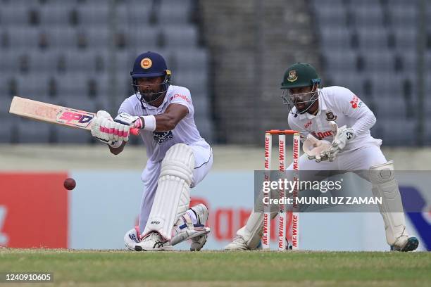 Sri Lanka's Dinesh Chandimal plays a shot as Bangladesh's wicketkeeper Liton Das watches during the fourth day of the second Test cricket match...