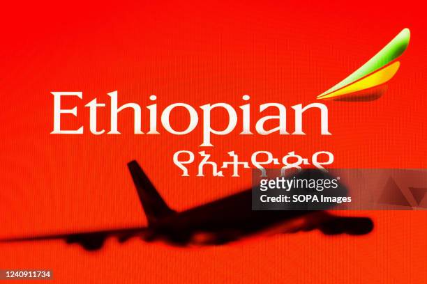 In this photo illustration, the Ethiopian Airlines logo is seen in the background of a silhouette of an Airbus A380 plane.
