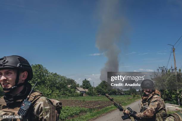 Two soldiers walk in front of a Russian missile fire in Donbass, Ukraine, 25 May 2022.