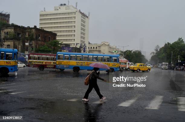 Girl with an umbrella crosses a road during heavy rainfall in Kolkata, India, 26 May, 2022.