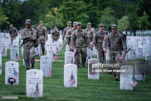Members of the 3rd U.S. Infantry Regiment arrive to place flags at the headstones of U.S. Military personnel buried at Arlington National Cemetery,...