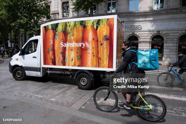 Food delivery of two kinds as a Sainsbury's internet groceries delivery van shares the same road as a Deliveroo cycle courier on 17th May 2022 in...