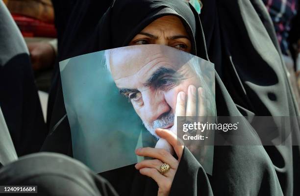 An Iranian carries a portrait of slain head of Iran's Islamic Revolutionary Guard Corps 's "Quds Force" Qasem Soleimani during a gathering at the...