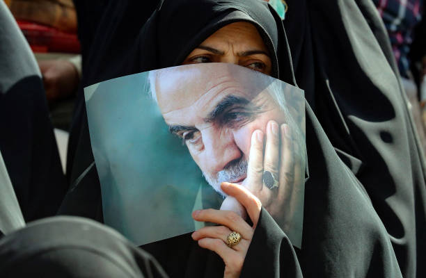 An Iranian carries a portrait of slain head of Iran's Islamic Revolutionary Guard Corps 's "Quds Force" Qasem Soleimani during a gathering at the...