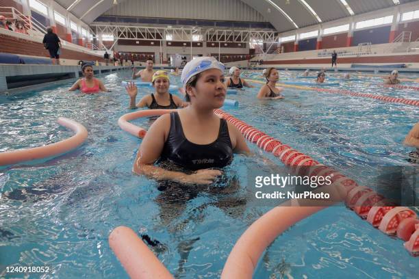 Group of inhabitants of Milpa Alta in Mexico City, Mexico, hold foami cylinders during an exhibition of Aqua Zumba or zumba in a swimming pool on the...