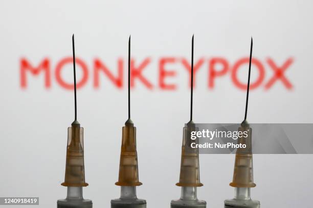 Medical syringes are seen with 'Monkeypox' sign displayed on a screen in the backgound in this illustration photo taken in Krakow, Poland on May 26,...