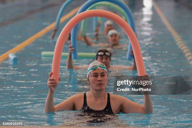 Group of inhabitants of Milpa Alta in Mexico City, Mexico, hold foami cylinders during an exhibition of Aqua Zumba or zumba in a swimming pool on the...