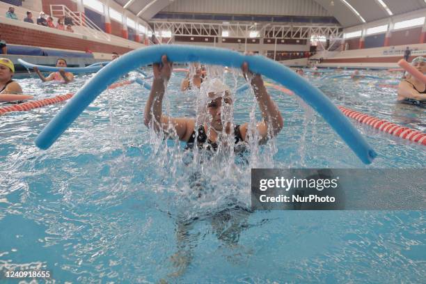 Group of inhabitants of Milpa Alta in Mexico City, Mexico, hold foami cylinders during an exhibition of Aqua Zumba or zumba in a swimming pool on the...