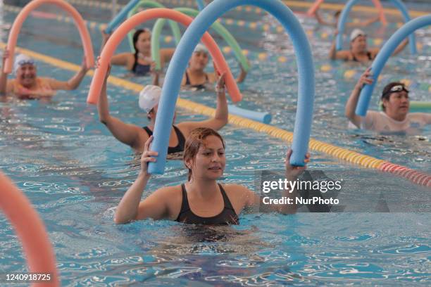 Group of inhabitants of Milpa Alta in Mexico City, Mexico, hold foami cylinders during an exhibition of Aqua Zumba or zumba in a swimming pool on the...