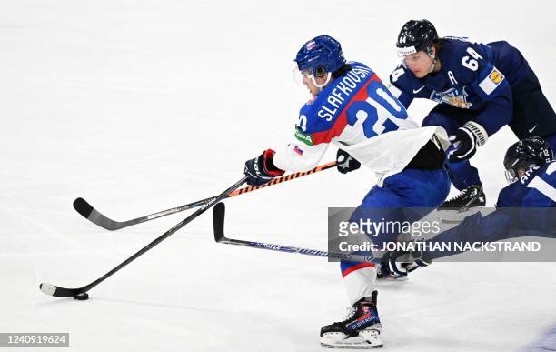 Finland's forward Mikael Granlund and Finland's forward Marko Anttila vie for the puck with Slovakia's forward Juraj Slafkovsky during the IIHF Ice...