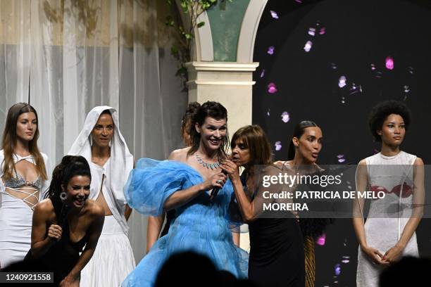 Actress Eva Longoria and US-Ukrainian actress Milla Jovovich and French editor Carine Roitfeld conduct an auction on May 26, 2022 flanked by Russian...