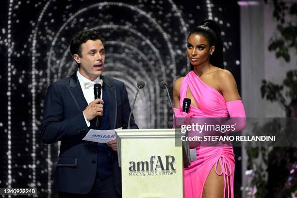 Actor Casey Affleck and US singer Ciara present items to be auctioned off on May 26, 2022 during the annual amfAR Cinema Against AIDS Cannes Gala at...