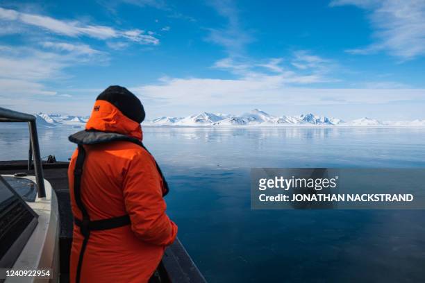 Passenger on the Kvitbjorn , a hybrid touristic boat, combining a diesel motor and electric batteries, looks on as it makes its way in the sea ice in...