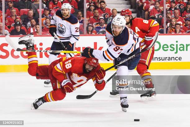 Oliver Kylington of the Calgary Flames chases the puck against Connor McDavid of the Edmonton Oilers during the first period of Game Five of the...