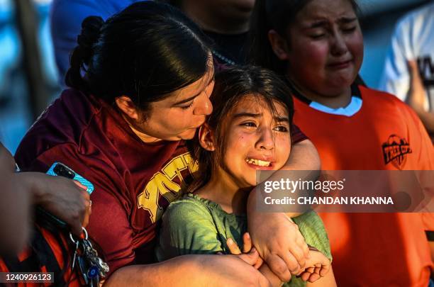 Gabriella Uriegas, a soccer teammate of Tess Mata who died in the shooting, cries while holding her mother Geneva Uriegas as they visit a makeshift...