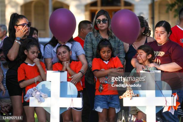 People visit memorials for victims of Tuesday's mass shooting at a Texas elementary school, in City of Uvalde Town Square on May 26, 2022 in Uvalde,...