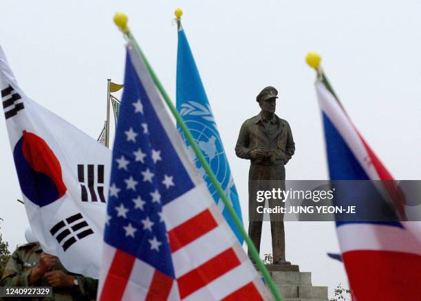 Flags held by South Korean veterans float in front of the statue of late US Army General Douglas MacArthur in Incheon, west of Seoul, 15 September...
