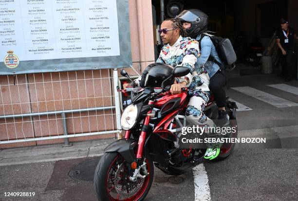 Mercedes' British driver Lewis Hamilton rides a motorcycle ahead of the first practice session of the Monaco Formula 1 Grand Prix, on May 27, 2022.