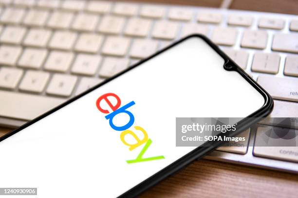 In this photo illustration, an eBay logo seen displayed on a smartphone on top of a computer keyboard.
