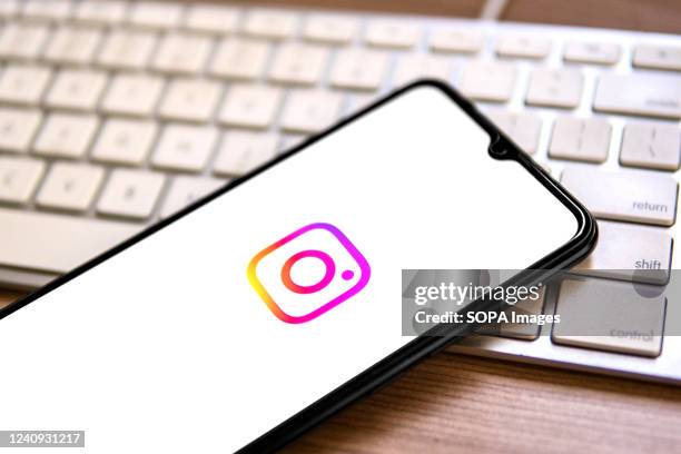 In this photo illustration, an Instagram logo seen displayed on a smartphone on top of a computer keyboard.