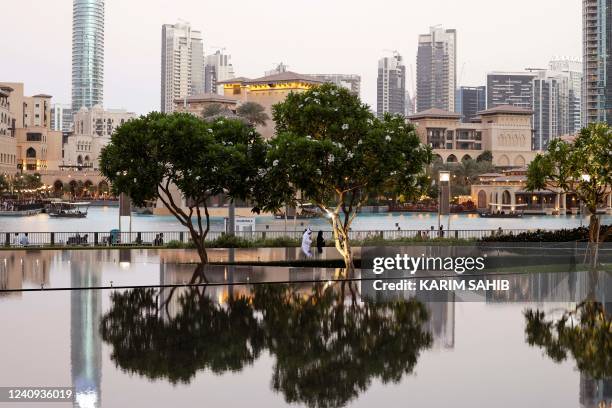 People visit a park the Burj Khalifa tower in the Gulf Emirate of Dubai on May 27, 2022.