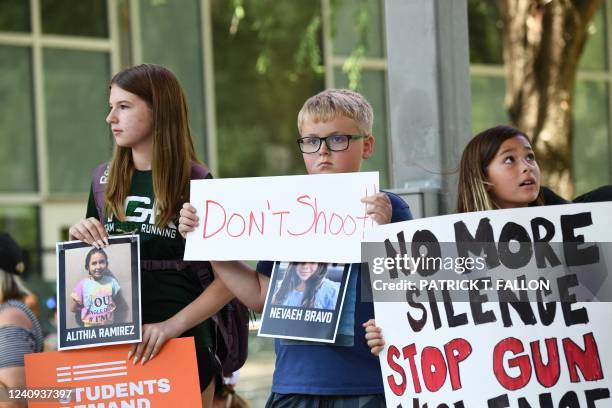 Children holding signs and photos of victims of the Robb Elementary School shooting, protest outside the National Rifle Association Annual Meeting at...