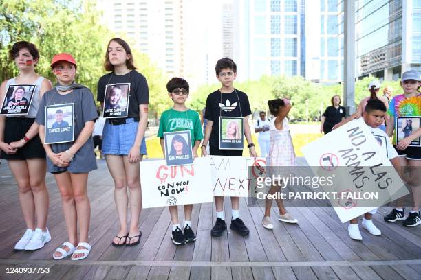Children holding photos of victims of the Robb Elementary School shooting, protest outside the National Rifle Association Annual Meeting at the...
