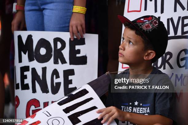 Child holding a sign, participates in a protest outside the National Rifle Association Annual Meeting at the George R. Brown Convention Center, on...
