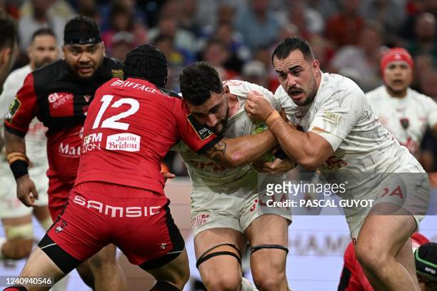 Toulon's French flanker Charles Ollivon and Toulon's French prop Jean-Baptiste Gros vie with Lyon's New Zealander centre Charlie Ngatai during the...
