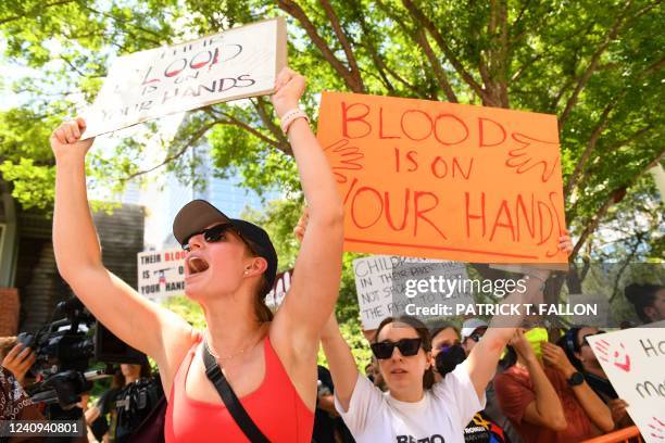 Protesters in support of gun control hold signs outside the National Rifle Association Annual Meeting at the George R. Brown Convention Center, on...