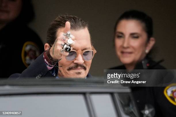 Actor Johnny Depp gives a thumbs up toward fans as he departs the Fairfax County Courthouse on May 27, 2022 in Fairfax, Virginia. Closing arguments...