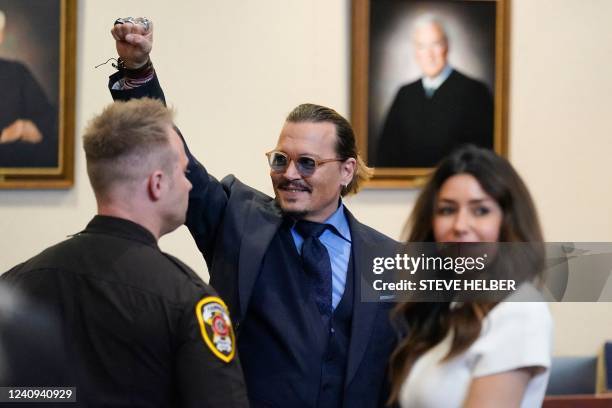 Actor Johnny Depp gestures to spectators in court after closing arguments at the Fairfax County Circuit Courthouse in Fairfax, Virginia, on May 27,...