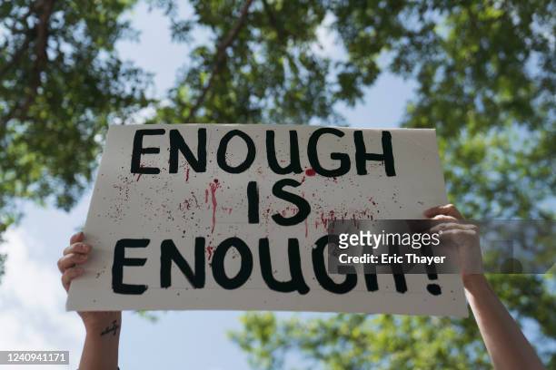 Gun control advocate holds a sign during a protest at Discovery Green across from the National Rifle Association Annual Meeting at the George R....