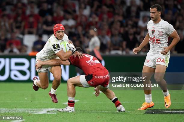 Toulon's South African wing Cheslin Kolbe is tackled by Lyon's French scrum-half Baptiste Couilloud during the European Challenge Cup rugby union...