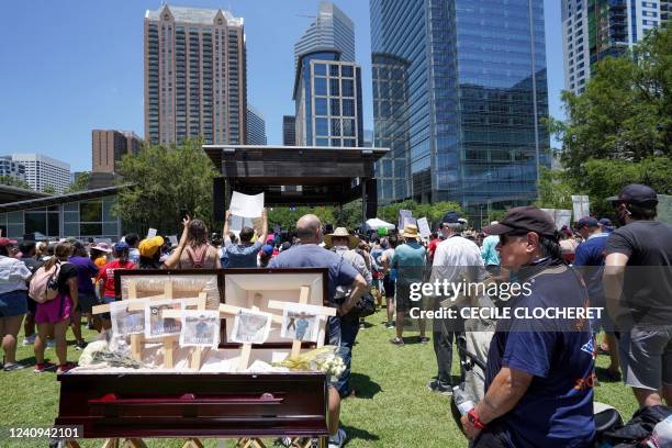 Casket with crosses bearing the pictures and names of children killed in a school shooting is displayed as anti-gun demonstrators gather at Discovery...