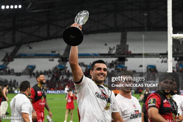 Lyon's French flanker Dylan Cretin celebrates with the trophy after winning the European Challenge Cup rugby union final match between Lyon Olympique...