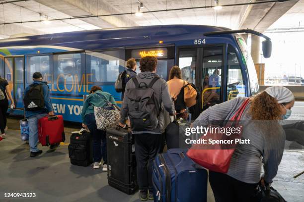 Travelers board a shuttle bus at John F. Kennedy Airport at the start of the Memorial Day weekend on May 27, 2022 in New York City. The holiday...