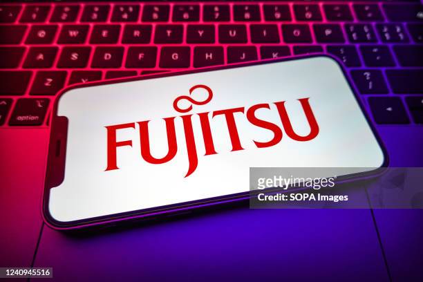 In this photo illustration, a Fujitsu logo is displayed on the screen of the smartphone.